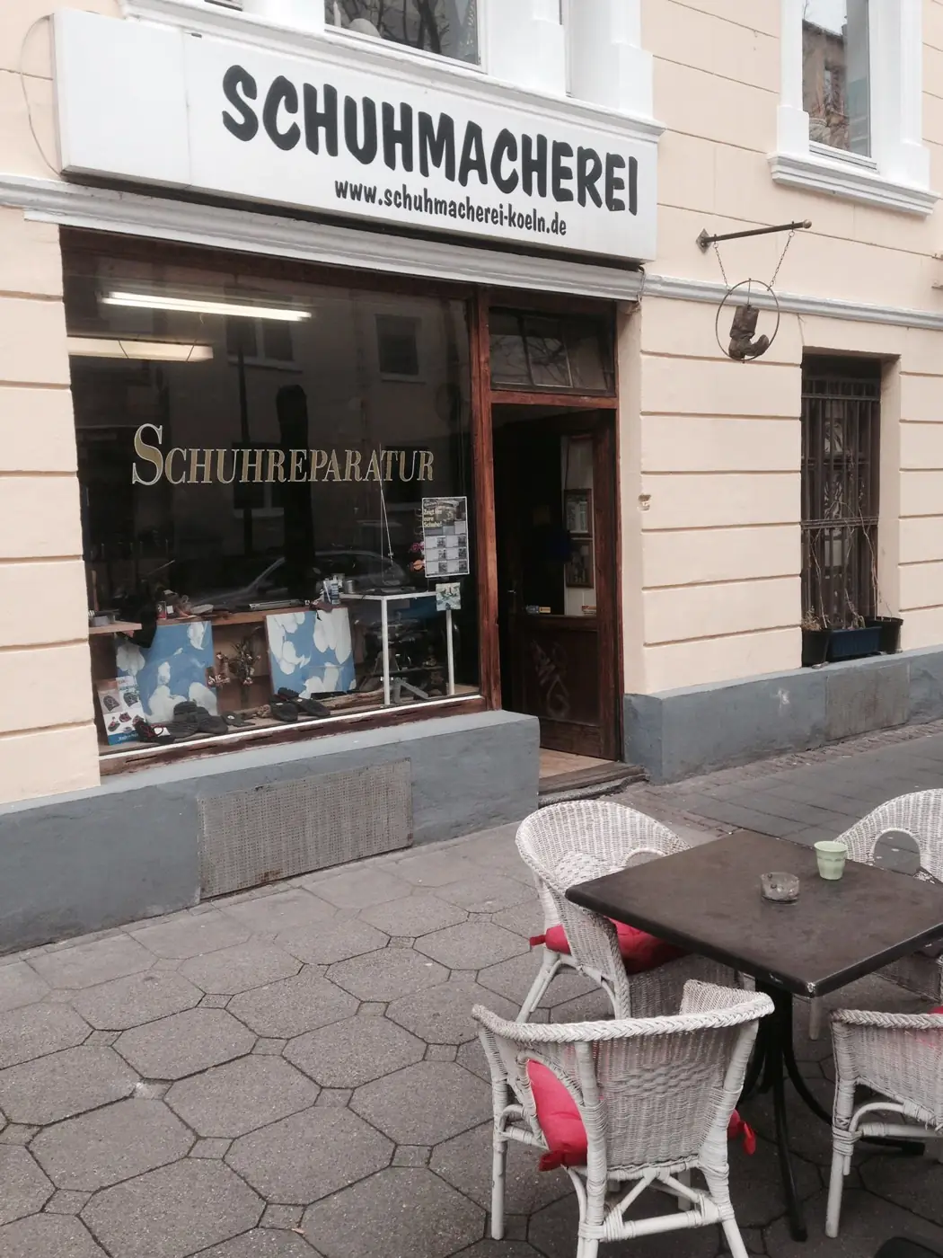 Ladenfront der Schuhmacherei in der Darmstädter Straße 7 mit dem handgemalten Schild