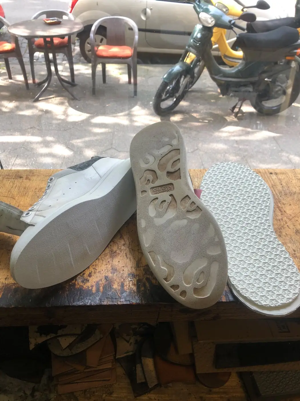 Sneaker vor der Reparatur: abgelaufene Sohle neben dem neuen Sohlenrohling