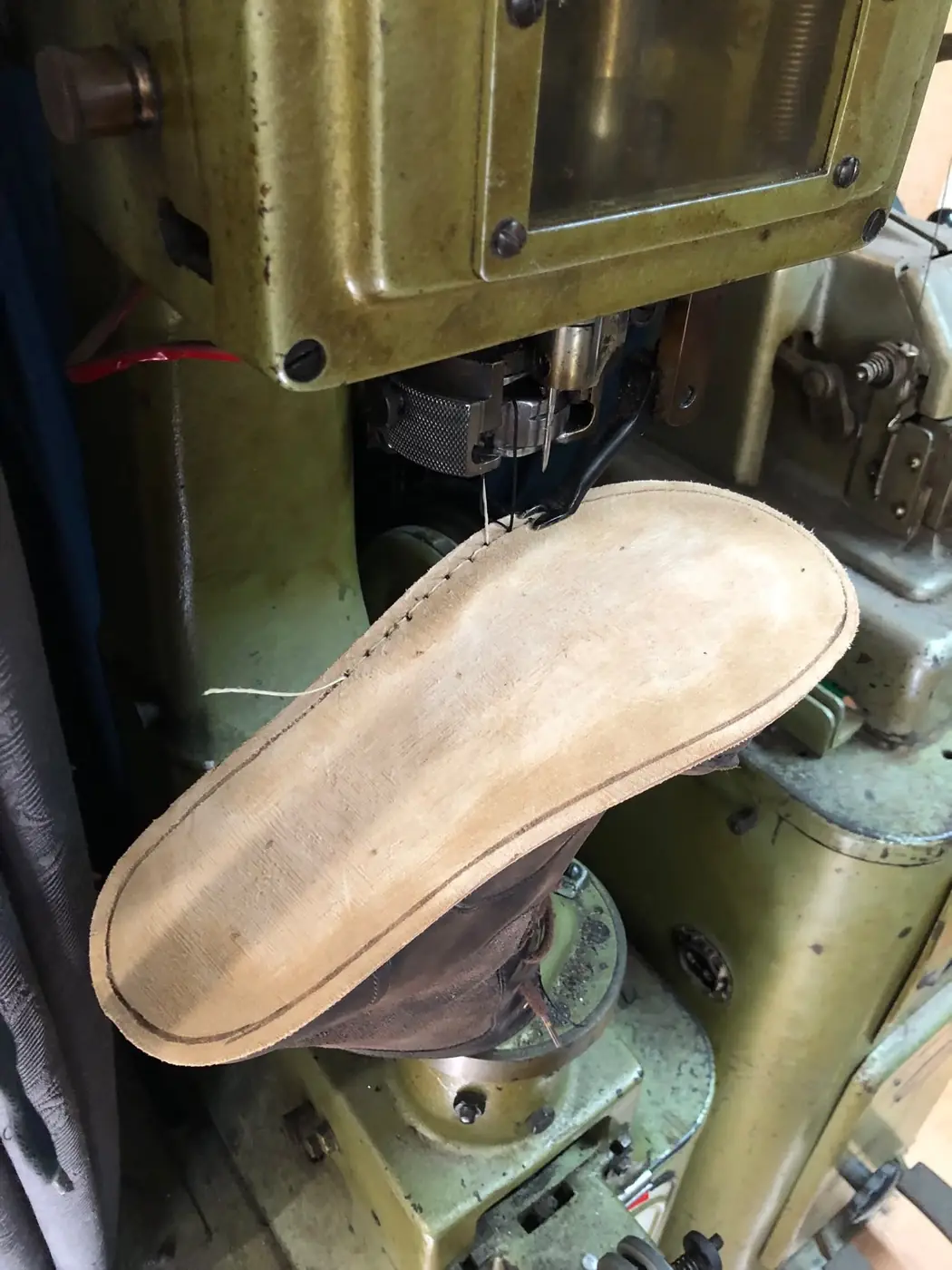 Eine neue Sohle wird an der Maschine vernäht