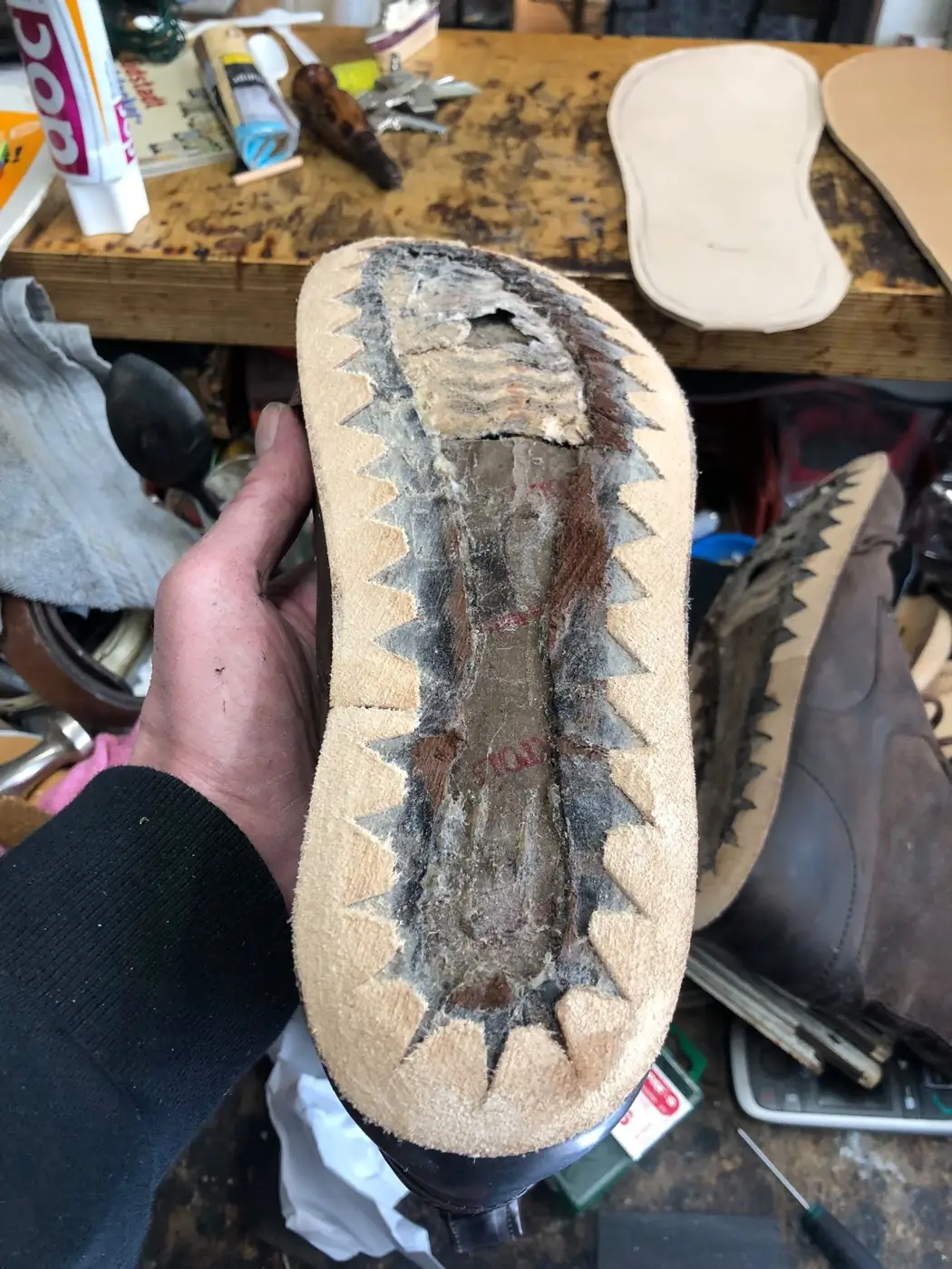 Stiefel, dessen alter Sohlenaufbau gerade entfernt ist